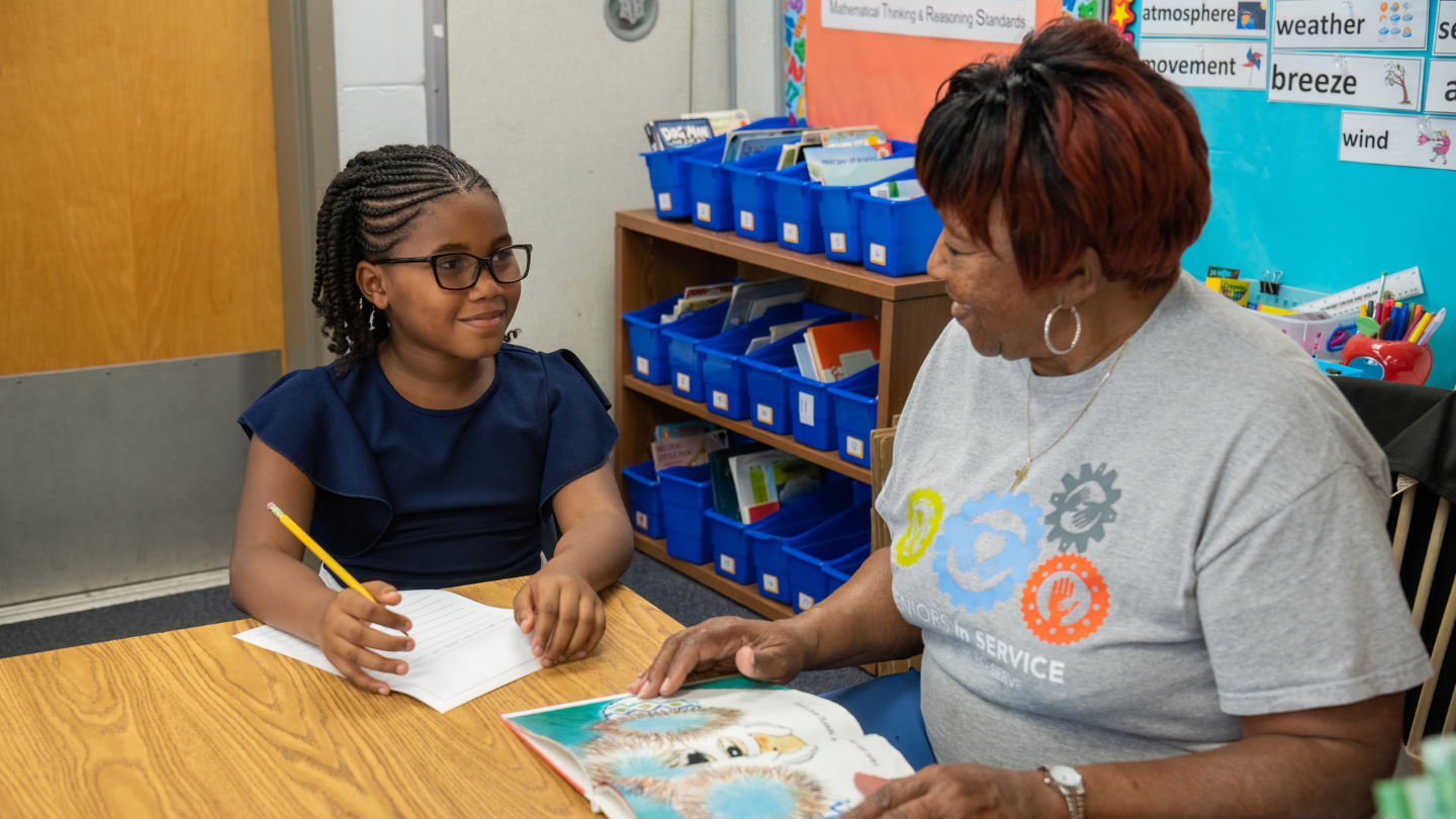 foster grandparent working with an elementary school student