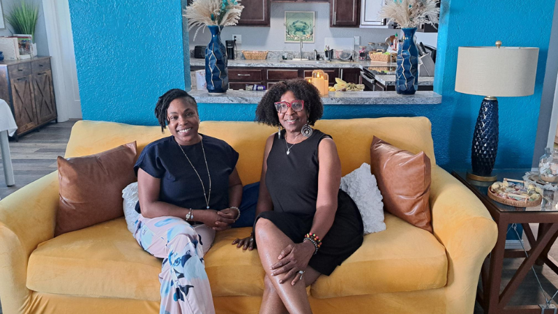 Juanita and Nuavia of Golden Generations sitting on a yellow sofa