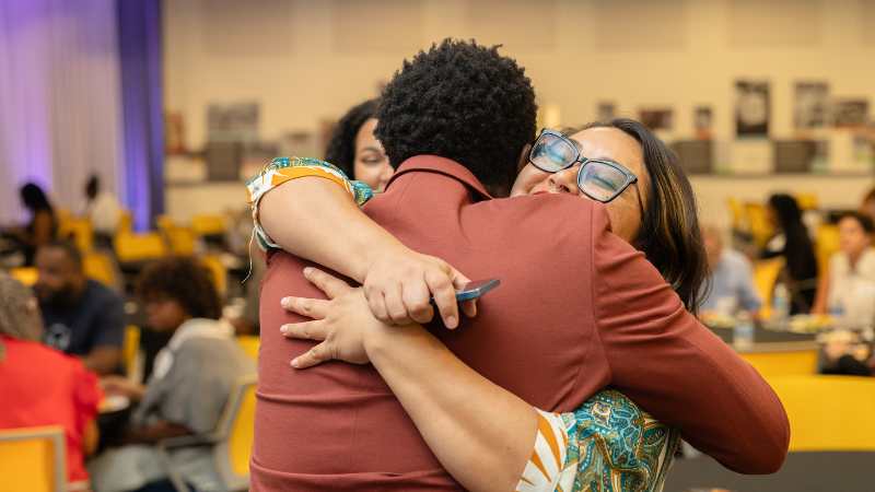 Two community members hugging at a Foundation event